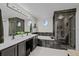 Modern bathroom with dual sinks, soaking tub, and walk-in glass shower featuring dark tile at 1126 S Davenport Ct, Erie, CO 80516