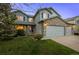 Well-manicured lawn and flower beds accentuate this two-story home with a stone-clad three car garage at 1126 S Davenport Ct, Erie, CO 80516