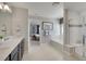 A well-lit bathroom featuring dual vanities, a soaking tub, and a separate glass-enclosed shower at 1166 Ridgefield Dr, Berthoud, CO 80513