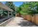 Gravel backyard area with a covered patio and wood fence at 5986 Dunraven St, Golden, CO 80403