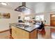Open-concept kitchen island with cooktop, connecting to the living area for seamless entertaining at 5986 Dunraven St, Golden, CO 80403