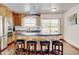 Spacious kitchen island featuring seating, a cooktop, and a seamless flow to the dining area at 5986 Dunraven St, Golden, CO 80403