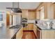 Modern kitchen with stainless steel appliances, sleek countertops, and natural wood cabinets at 5986 Dunraven St, Golden, CO 80403