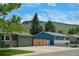 Street view featuring a lovely green home with an oversized detached garage at 5986 Dunraven St, Golden, CO 80403
