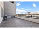 Spacious outdoor patio with wood-look tiling, grill, and city views with metal and glass railing at 1616 S Broadway # 206, Denver, CO 80210