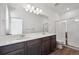 A modern bathroom featuring double sinks, a vanity, and a glass enclosed shower at 1238 Penner Dr, Erie, CO 80026