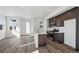 Open-concept kitchen with stainless steel appliances, an island, and sleek dark brown cabinetry at 1238 Penner Dr, Erie, CO 80026