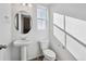 Clean powder room featuring a pedestal sink, oval mirror, and contemporary fixtures at 1238 Penner Dr, Erie, CO 80026