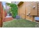 A well-maintained backyard featuring artificial turf, a charming patio, and lush greenery at 1519 S Dayton St, Denver, CO 80247