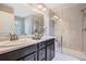 Bright bathroom featuring a double vanity, a spacious shower, and modern fixtures at 1519 S Dayton St, Denver, CO 80247