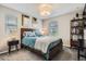 Well-lit bedroom showcases a wooden bed frame, soft blue accents, and a stylish bedside table at 1519 S Dayton St, Denver, CO 80247