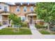 Inviting townhome entrance with stone accents, lush landscaping, and a well-maintained lawn at 1519 S Dayton St, Denver, CO 80247