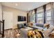 Cozy living room featuring wood floors, a comfortable gray sofa, and large windows at 1519 S Dayton St, Denver, CO 80247
