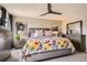 Spacious main bedroom with a ceiling fan, a colorful floral comforter, and lots of natural light at 1519 S Dayton St, Denver, CO 80247
