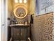 The powder room features unique wallpaper, a decorative mirror, and a sleek black vanity at 1519 S Dayton St, Denver, CO 80247