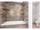 Bathroom featuring a tiled tub, shower, and flooring with neutral stone and tile design at 2101 S Victor St # C, Aurora, CO 80014
