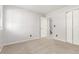 Well-lit bedroom with neutral carpet, and closet, freshly painted walls, and a doorway to the stairway at 2101 S Victor St # C, Aurora, CO 80014