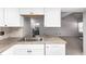 Well-lit kitchen featuring a stainless steel sink and white appliances that complement the neutral stone countertops at 2101 S Victor St # C, Aurora, CO 80014