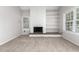 Living room with a white brick fireplace and built in shelves, featuring bright natural light at 2101 S Victor St # C, Aurora, CO 80014