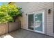 Private patio with mature landscaping, sliding glass door and exterior wall mounted lighting at 2101 S Victor St # C, Aurora, CO 80014
