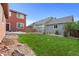 Lush backyard featuring a well-manicured lawn, river rock landscaping, and patio at 11034 Nome St, Commerce City, CO 80640
