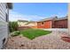 Well-maintained backyard with grass, river rock landscaping, patio, and adjacent home at 11034 Nome St, Commerce City, CO 80640