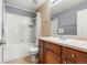 Cozy bathroom featuring a shower and tub combo, tiled floors, and a wooden vanity at 11034 Nome St, Commerce City, CO 80640