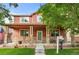 Charming two-story home featuring a welcoming front porch with stone accents and a well-maintained lawn at 11034 Nome St, Commerce City, CO 80640
