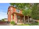 Inviting home exterior with a covered porch, stone accents, an American flag, and mature landscaping at 11034 Nome St, Commerce City, CO 80640