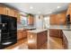 Bright kitchen with a center island, wooden cabinets, stainless steel sink, and black appliances at 11034 Nome St, Commerce City, CO 80640