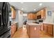 Spacious kitchen with wood cabinets, center island, hardwood floors, and modern black appliances at 11034 Nome St, Commerce City, CO 80640