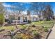 Charming green cottage with a front porch swing and blossoming front yard landscaping at 4476 S Lincoln St, Englewood, CO 80113