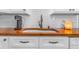 Close-up of the kitchen sink with butcher block countertop and subway tile backsplash at 4476 S Lincoln St, Englewood, CO 80113
