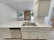 Kitchen with breakfast bar featuring stainless steel sink and view of brick fireplace at 3986 S Bahama St, Aurora, CO 80013