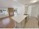 Open kitchen with breakfast bar, sink, tile floors and view of the brick fireplace at 3986 S Bahama St, Aurora, CO 80013