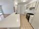 Bright kitchen with quartz countertops, tile floors, and stainless steel appliances at 3986 S Bahama St, Aurora, CO 80013