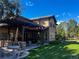 Lush backyard with a covered patio, manicured lawn, and mature trees at 9552 E Silent Hills Pl, Lone Tree, CO 80124
