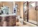 Bathroom featuring a sink with dark wood cabinets and walk-in shower with glass door at 9552 E Silent Hills Pl, Lone Tree, CO 80124