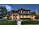 Elegant home exterior featuring beautiful stonework, manicured lawn, and decorative outdoor lighting at 9552 E Silent Hills Pl, Lone Tree, CO 80124