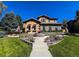 Stunning home with lush landscaping, a stone water fountain, and a welcoming walkway at 9552 E Silent Hills Pl, Lone Tree, CO 80124
