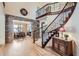 Grand foyer with a staircase, stone accent wall, and hardwood floors at 9552 E Silent Hills Pl, Lone Tree, CO 80124
