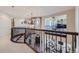 Open hallway with decorative wrought iron railings, staircase, and views into the living room and sitting room at 9552 E Silent Hills Pl, Lone Tree, CO 80124