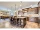 Open kitchen with natural wood island and cabinets, eat in dining, and stone backsplash at 9552 E Silent Hills Pl, Lone Tree, CO 80124