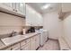 Well-organized laundry room featuring modern washer and dryer, ample storage, and a utility sink at 9552 E Silent Hills Pl, Lone Tree, CO 80124