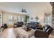 Comfortable living room with leather couches, area rug, ceiling fan and large windows at 9552 E Silent Hills Pl, Lone Tree, CO 80124
