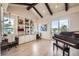 Bright room with vaulted ceilings, exposed wood beams, built-in bookshelves and cabinets, and a grand piano at 9552 E Silent Hills Pl, Lone Tree, CO 80124