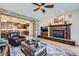 Cozy living room with stone fireplace, leather chair, and open to kitchen and dining at 9552 E Silent Hills Pl, Lone Tree, CO 80124