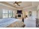 Spacious main bedroom featuring a fireplace, ceiling fan, and large windows with bright, natural light at 9552 E Silent Hills Pl, Lone Tree, CO 80124