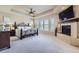 Serene primary bedroom with a fireplace, tray ceiling, and plush carpeting at 9552 E Silent Hills Pl, Lone Tree, CO 80124