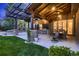 Outdoor kitchen and dining area under a pergola, featuring a built-in grill and ample seating at 9552 E Silent Hills Pl, Lone Tree, CO 80124